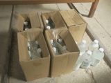 des cartons d'eau en bouteille posés par terre à côté d'une table