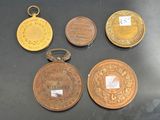 several different types of medals are displayed on a black surface