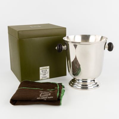 un seau à glace en argent, avec à côté un chiffon marron et une boîte verte