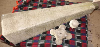 un gros objet en ciment posé sur une couverture, avec un ours en peluche