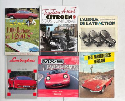 plusieurs livres posés sur une table blanche, avec une voiture rouge et une voiture rouge