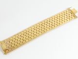 a close up of a gold bracelet on a white surface