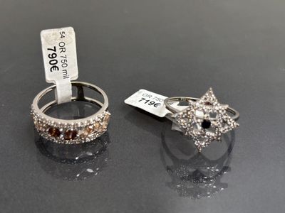 paire de bagues en argent ornées de diamants bruns et blancs sur un fond noir
