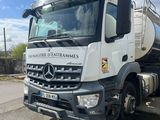 un camion blanc garé sur le bord de la route