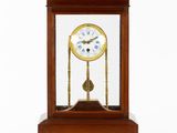 une petite horloge en bois surmontée d'une vitrine