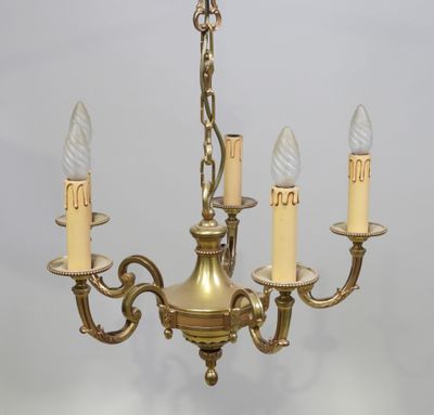 une image représentant un lustre sur lequel sont disposées trois bougies sur chacune de ses branches