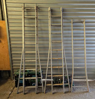 four ladders that are leaning against a garage door