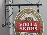 a sign hanging from the side of a building that says stella artus