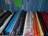 a lot of different colors of fabric on a shelf