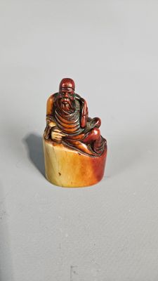 an image of a small figurine of a man sitting on a rock
