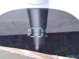 a digital clock on top of a table next to a cup of coffee