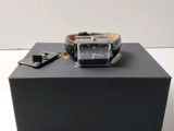 une montre posée sur une boîte, elle-même posée sur une table
