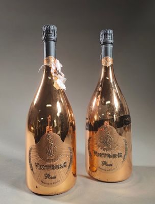 two bottles of champagne sitting next to each other on top of a table