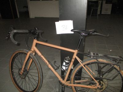 un vélo garé à côté d'un poteau sur lequel est accrochée une pancarte
