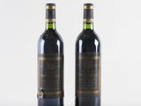 two bottles of wine sitting next to each other on a white surface