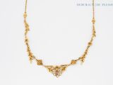gros plan d'un collier en or sur fond blanc