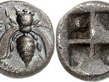 a silver coin with an image of a spider on it