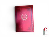 a red book on a white surface with a red cover