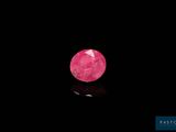 a close up of a pink diamond on a black surface