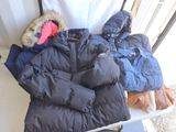 une pile de manteaux et de gants posée sur une table
