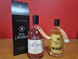 deux bouteilles de whisky posées sur une table à côté d'une boîte noire