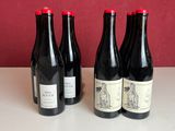 trois bouteilles de vin sont alignées sur un plan de travail