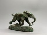 statue en bronze représentant un éléphant posé sur un rocher, sur fond blanc