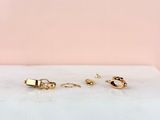 a pair of gold hoop earrings on a marble surface