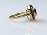 an image of a close up of a gold ring on a white surface