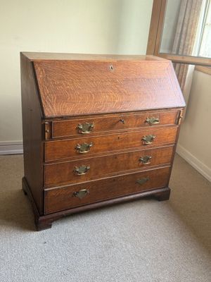 un petit bureau en bois avec des tiroirs dans une pièce