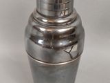 un vase en argent posé sur une surface blanche