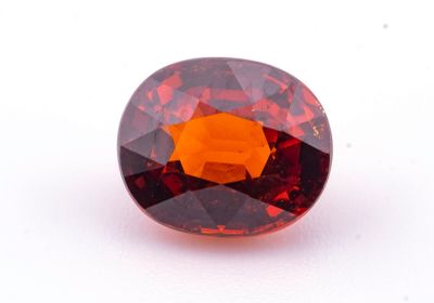 un gros plan d'une pierre de grenat rouge sur une surface blanche