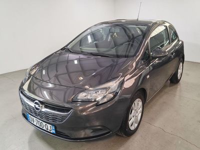 L'Opel grise est garée dans une grande pièce aux murs blancs.
