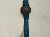 a close up of a watch on a white surface with a blue strap