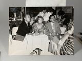 a black and white photo of a group of people sitting at a table