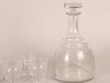 a glass decanter and glasses sitting on a table