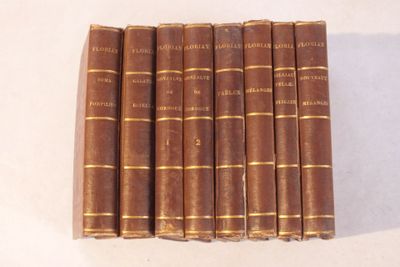 six vieux livres sont alignés sur une surface blanche