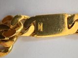 a close up of a gold chain with a watch on it