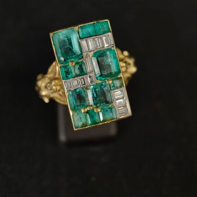 Gros plan sur une bague en or ornée d'émeraudes et de diamants
