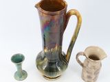 two vases and a pitcher sitting next to each other