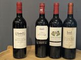three bottles of red wine sitting on top of a wooden barrel