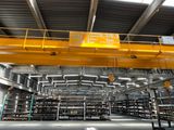 a large yellow crane in a warehouse with lots of shelves