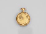 a gold pocket watch with a floral design on the front