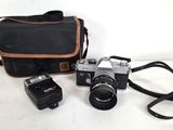 a camera, flash and a camera case on a table