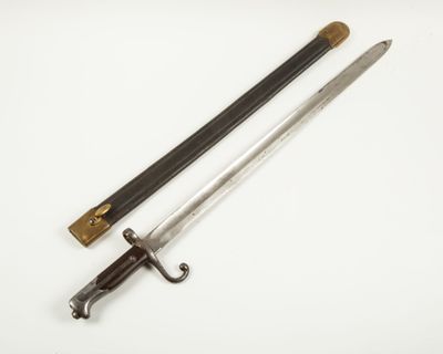 une vieille épée avec un manche en bois sur une surface blanche