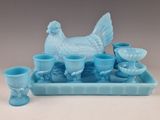 a blue tray with a chicken and cups on it