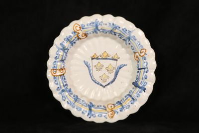 a blue and white plate with a crest on it