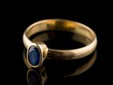 a close up of a gold ring with a blue stone