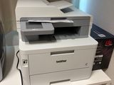 une imprimante blanche posée sur un meuble blanc