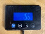 a digital clock on a table with a charger